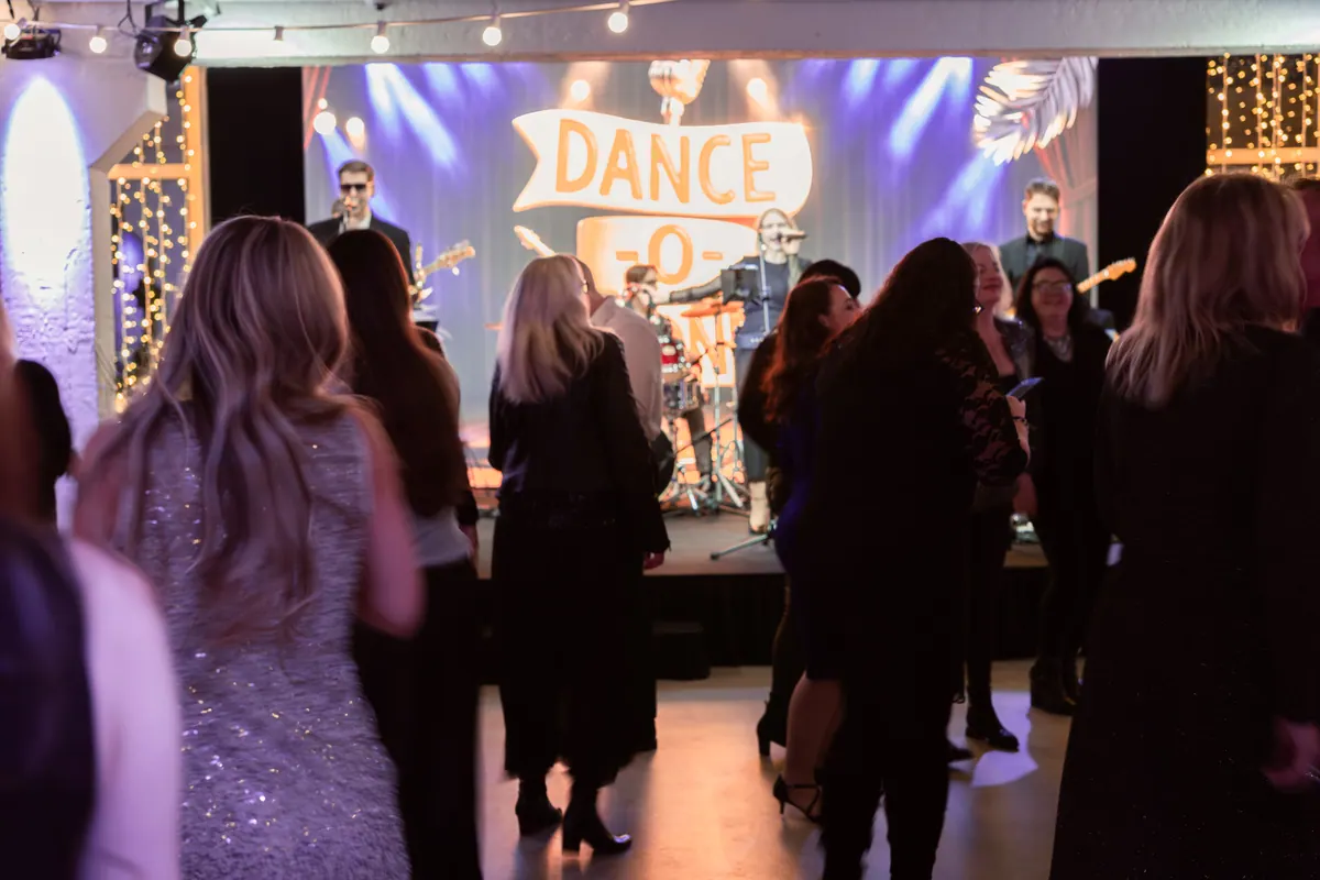 Täis tantsupõrand bändi ees, taustal helendav Dance-O-Phones'i valgussilt